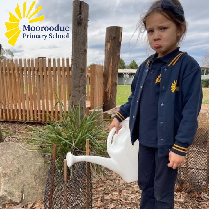 Girl in school uniform looking sad as her watering can is empty