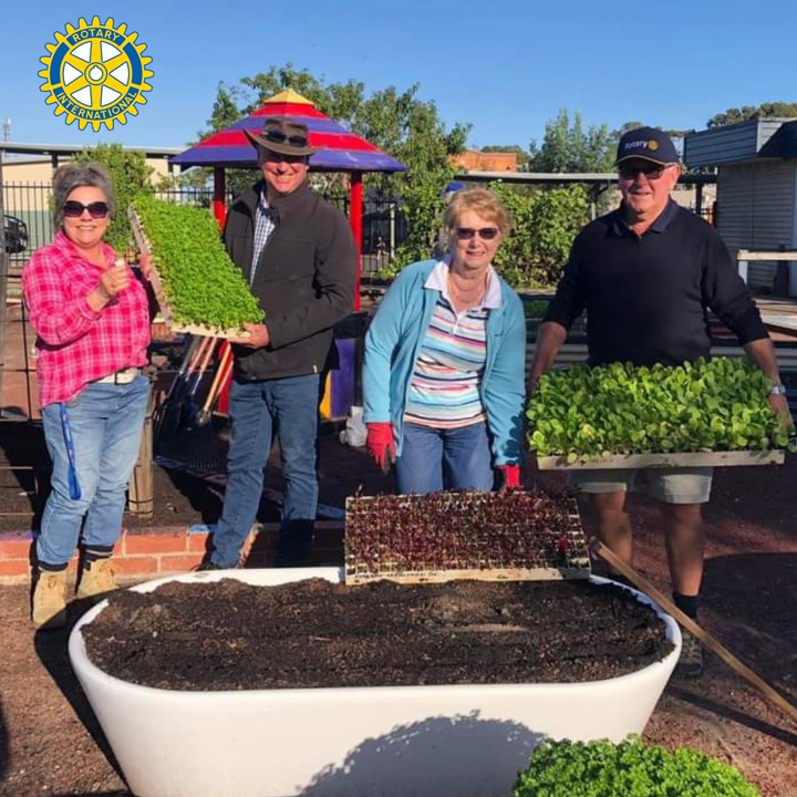 People standing in front of a bath with has been transformed into a outdoor garden bed. 