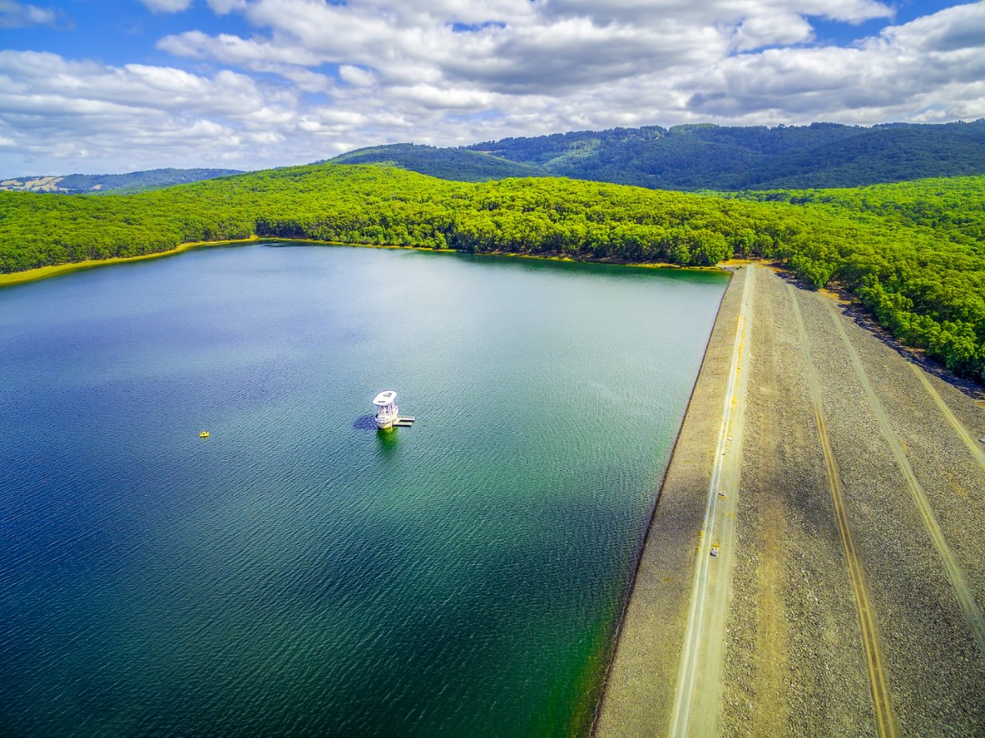 Aerial view of Silvan Reservoir lake dam wall and green hills. Melbourne, Australia